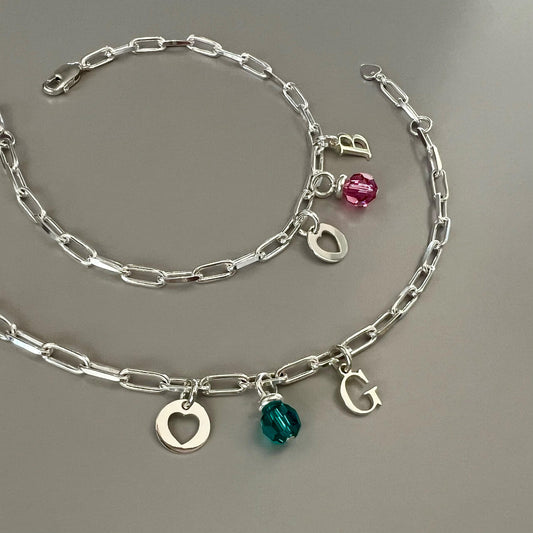 Personalsed dainty paper clip sterling silver chain bracelet with three charms, initial of your choice, round Austrian crystal birthsone and round heart disc, perfect for everyday wear.